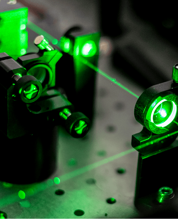 Green laser beams in optical laboratory setup.